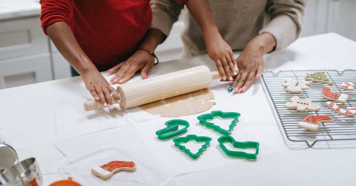 Processing time of a working holiday visa in New Zealand - From above of crop unrecognizable ethnic child rolling out dough near parent while preparing gingerbread cookies in kitchen Processing time of a working holiday visa in New Zealand - From above of crop unrecognizable ethnic child rolling out dough near parent while preparing gingerbread cookies in kitchen