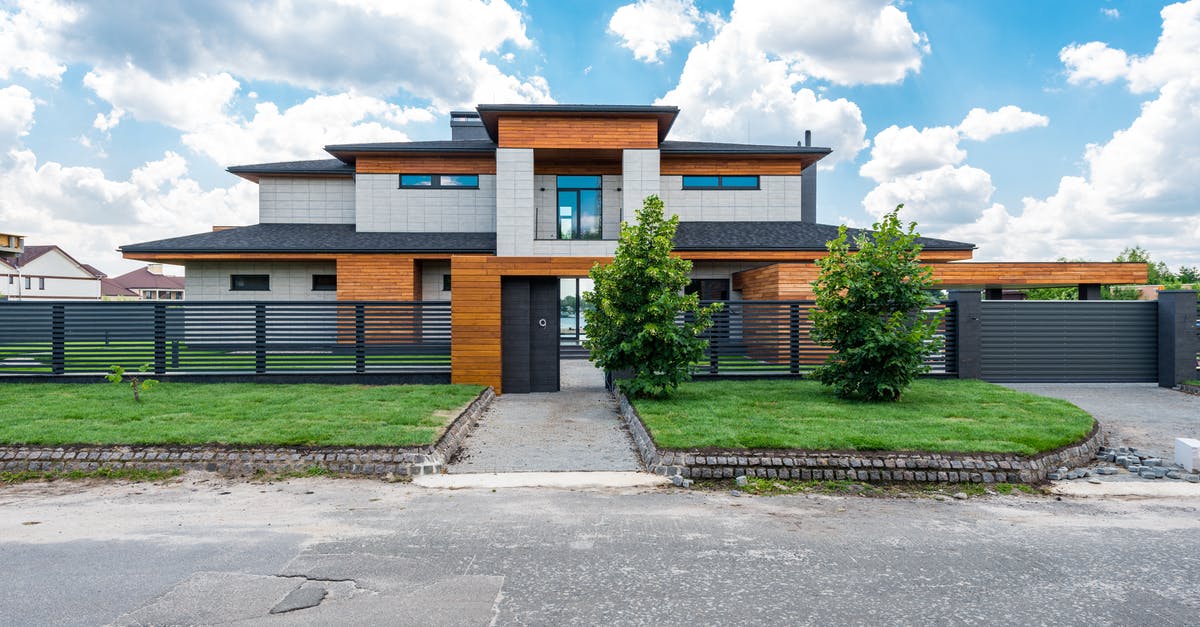 Proof of Accommodation in England - Facade of contemporary luxury villa building with lawn and green trees under blue sky with clouds Proof of Accommodation in England - Facade of contemporary luxury villa building with lawn and green trees under blue sky with clouds