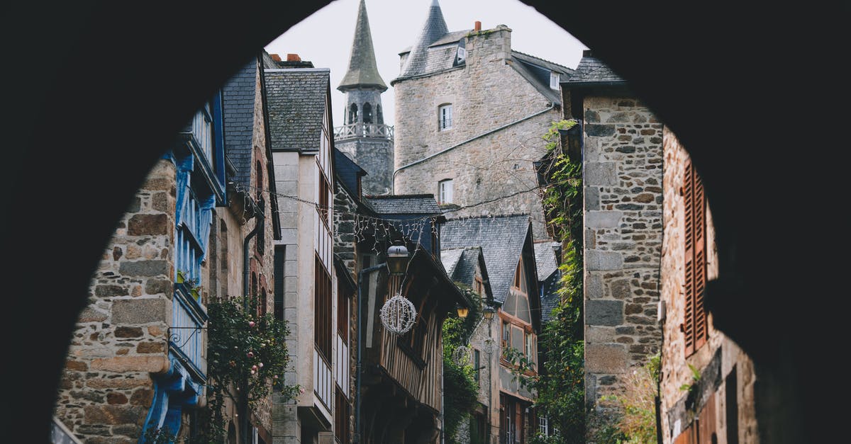 Proof of Accommodation: One day trip in France - Narrow street of old town with arched passage and typical stone houses Proof of Accommodation: One day trip in France - Narrow street of old town with arched passage and typical stone houses