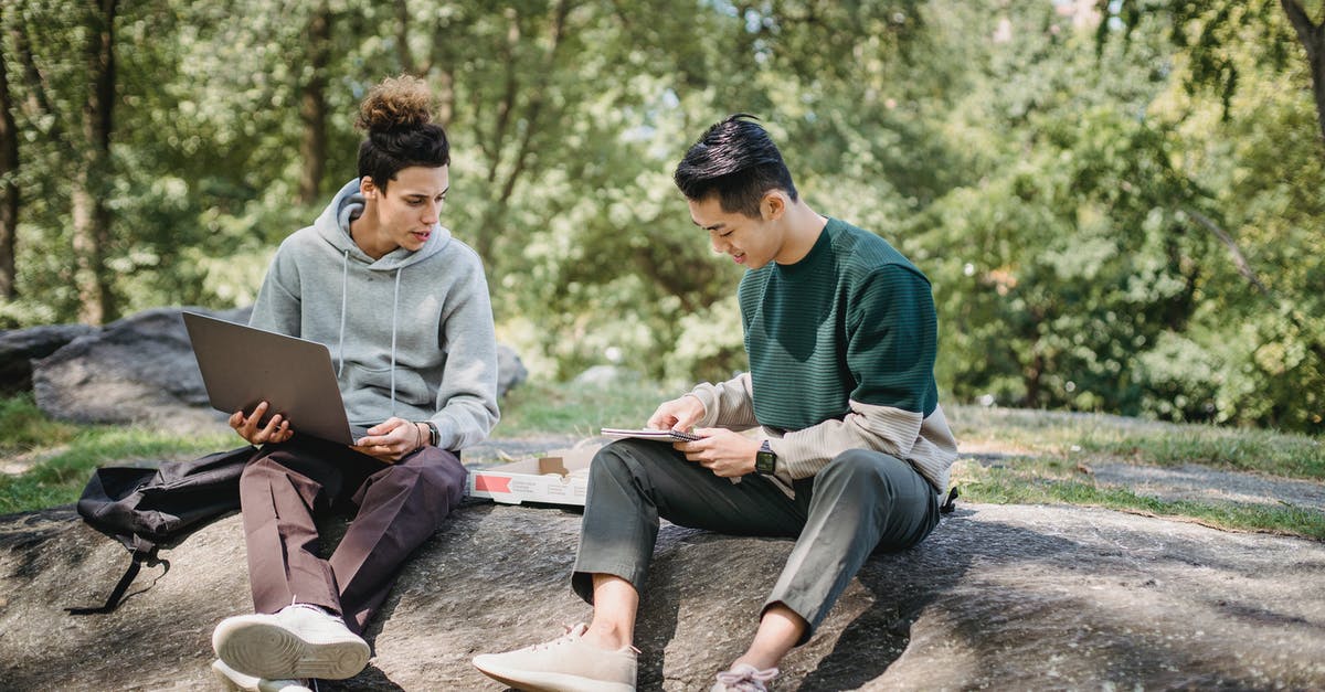 Proof of earnings - what to do if I am a full time student? - Full body young men in casual clothes spending time on ground with netbook and pizza while taking notes in notebook in summer sunny day with trees on background Proof of earnings - what to do if I am a full time student? - Full body young men in casual clothes spending time on ground with netbook and pizza while taking notes in notebook in summer sunny day with trees on background