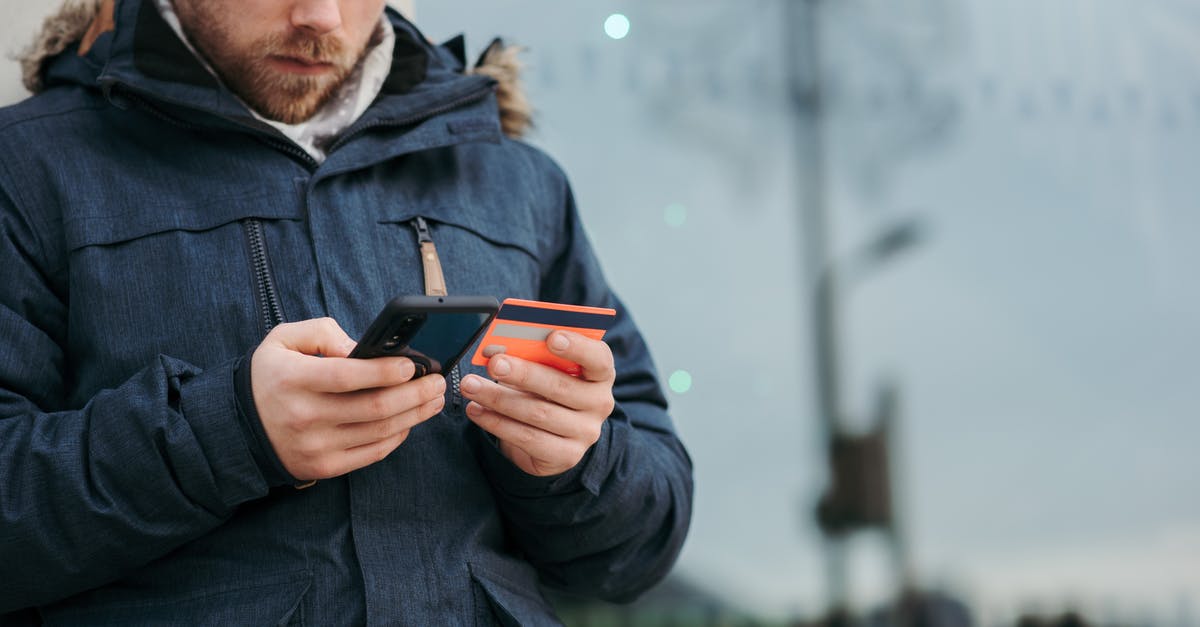 Proof of finance when entering the Ukraine as a German citizen - Crop concentrated man in warm clothes entering credentials of credit card on mobile phone while standing in street in daytime Proof of finance when entering the Ukraine as a German citizen - Crop concentrated man in warm clothes entering credentials of credit card on mobile phone while standing in street in daytime