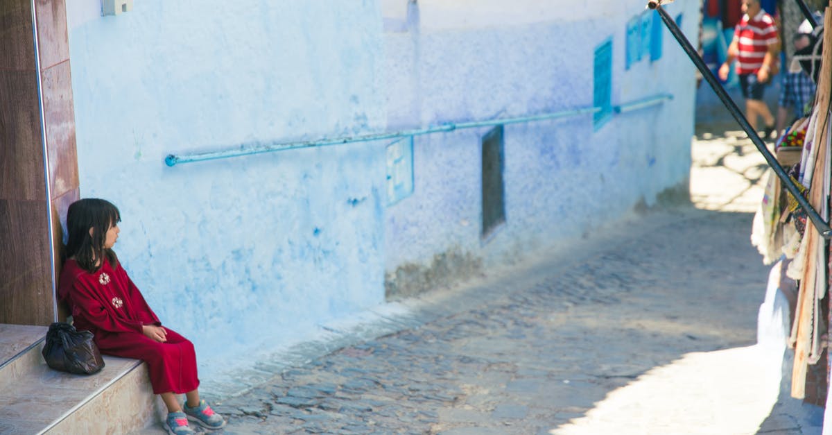 Public transportation considerations for children in North Eastern USA - Girl sitting on street stairs in indigenous outdoor market Public transportation considerations for children in North Eastern USA - Girl sitting on street stairs in indigenous outdoor market