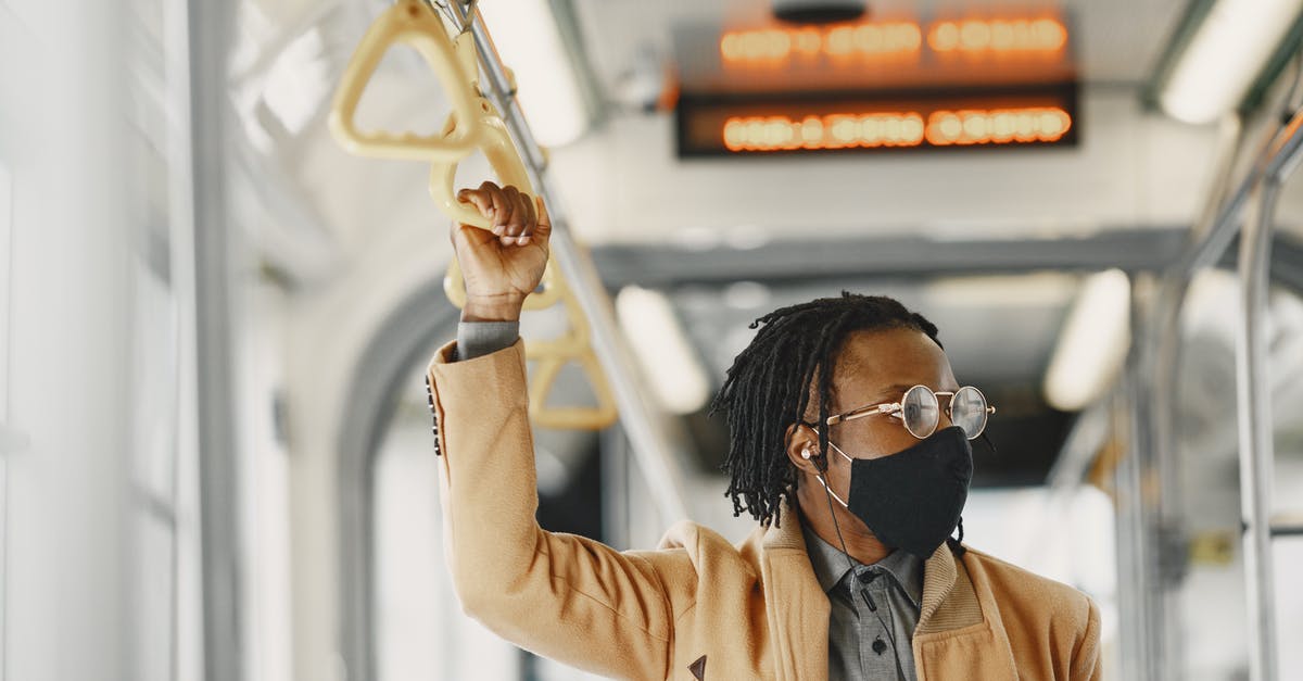 Pula to Trieste by Bus - Immigration check? - Man in Brown Coat Wearing Facemask and Eyeglasses Holding on Bus Handle Pula to Trieste by Bus - Immigration check? - Man in Brown Coat Wearing Facemask and Eyeglasses Holding on Bus Handle