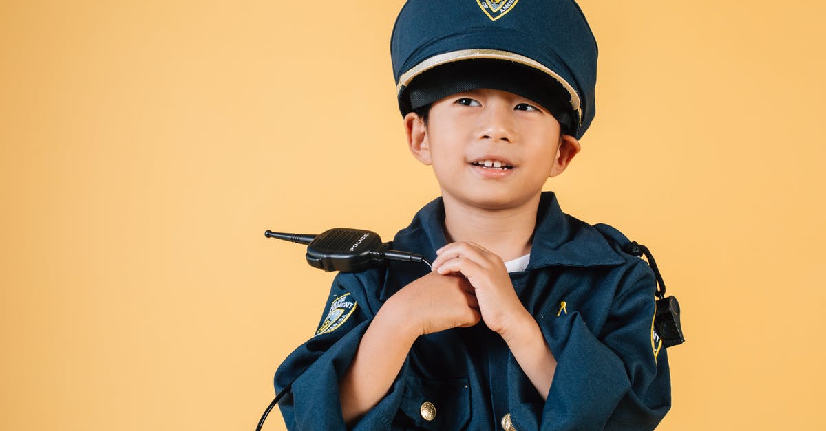 Purpose of the 'Witches' Hats' on the A13 in London - Pleasant Asian boy in police uniform and cap looking away while standing with hands near chest in studio on yellow background Purpose of the 'Witches' Hats' on the A13 in London - Pleasant Asian boy in police uniform and cap looking away while standing with hands near chest in studio on yellow background