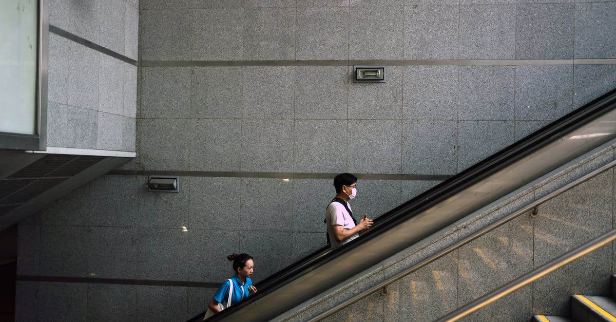 Quarantine Rule in New York - Anonymous man and woman on escalator during COVID 19 pandemic Quarantine Rule in New York - Anonymous man and woman on escalator during COVID 19 pandemic