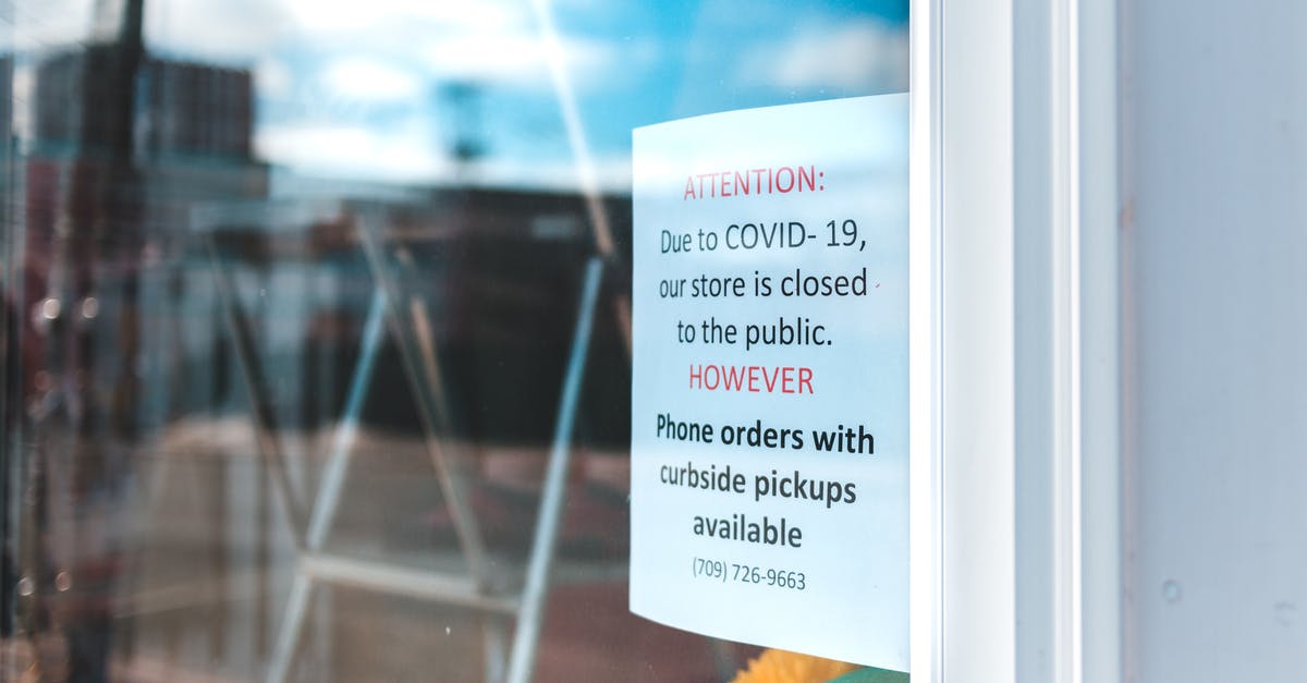 Quarantine Rule in New York - Paper sheet with warning information on glass wall of local city shop with portable ladder inside reflecting blue cloudy sky during quarantine period Quarantine Rule in New York - Paper sheet with warning information on glass wall of local city shop with portable ladder inside reflecting blue cloudy sky during quarantine period
