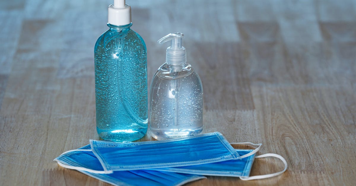 Quarantine Rule in New York - From above of transparent bottles with bubbled antiseptic liquid soap and gel near medical masks on table Quarantine Rule in New York - From above of transparent bottles with bubbled antiseptic liquid soap and gel near medical masks on table