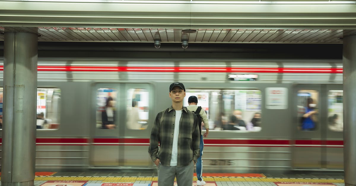 Quick way to exit King's Cross tube station? - Asian man standing on platform in underground Quick way to exit King's Cross tube station? - Asian man standing on platform in underground