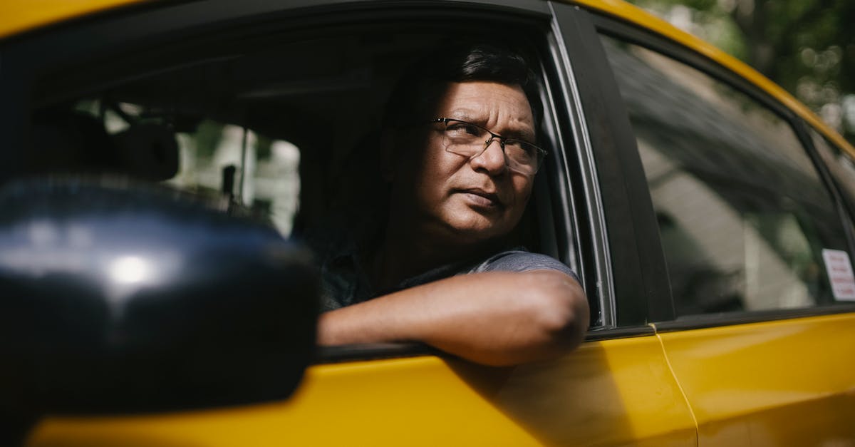 Radio program with public transport focus by country - Serious ethnic male driver looking at opened window of taxi Radio program with public transport focus by country - Serious ethnic male driver looking at opened window of taxi