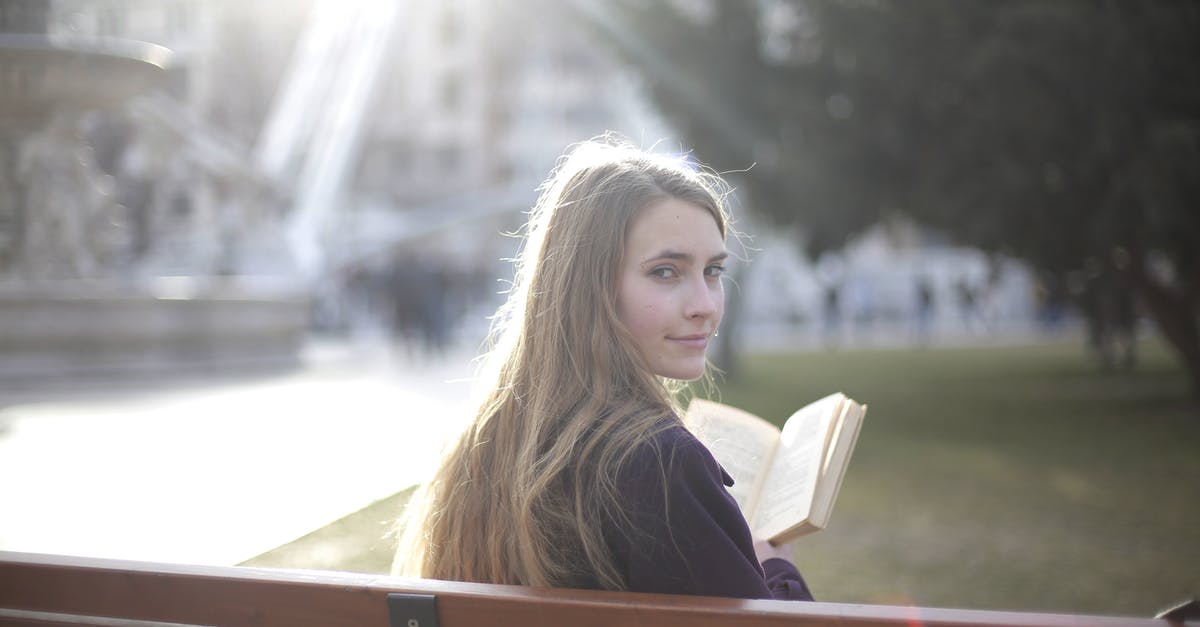 Re enter in UK over weekend ICT visa - Back view of peaceful female in casual jacket sitting on wooden bench in city park and enjoying story while relaxing and looking over shoulder