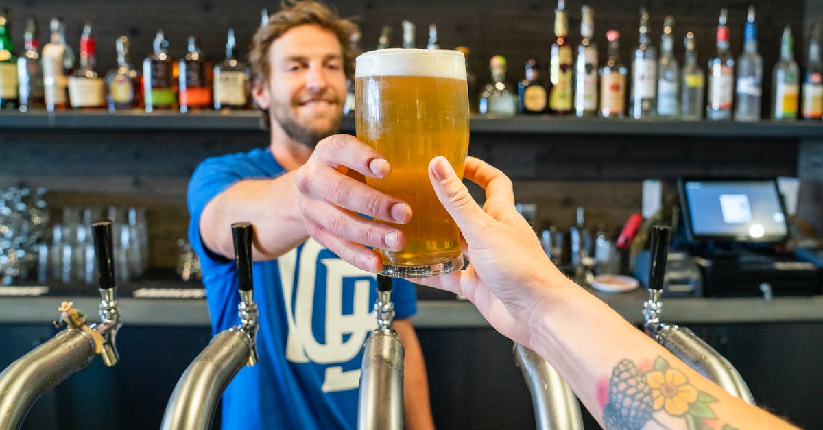 Received gestures in UK pubs: pint versus half-pint - Man Handing a Person a Glass of Beer Received gestures in UK pubs: pint versus half-pint - Man Handing a Person a Glass of Beer