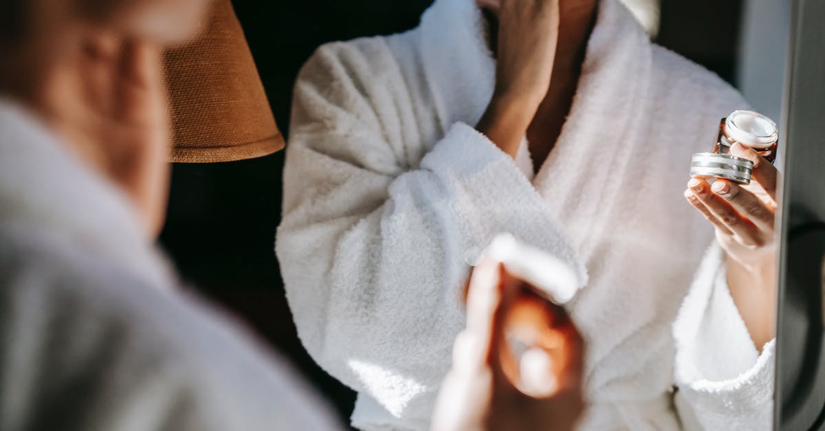Recently naturalized American visiting the UK, previously denied visa. Apply for entry clearance? - Black woman applying cream in  bathroom