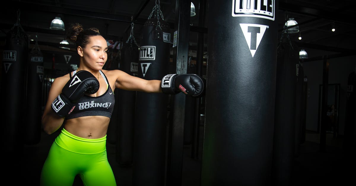 Re-check/check bags T5 to T3 on a separate itinerary - Athletic Woman in Sportswear Boxing Punching Bag Re-check/check bags T5 to T3 on a separate itinerary - Athletic Woman in Sportswear Boxing Punching Bag
