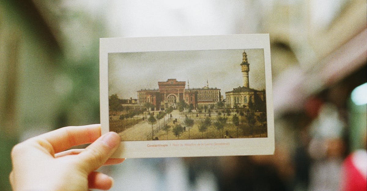 Recognize a place in Istanbul from an old (1890-1900) postcard - Crop person showing postcard with photography of old city Recognize a place in Istanbul from an old (1890-1900) postcard - Crop person showing postcard with photography of old city