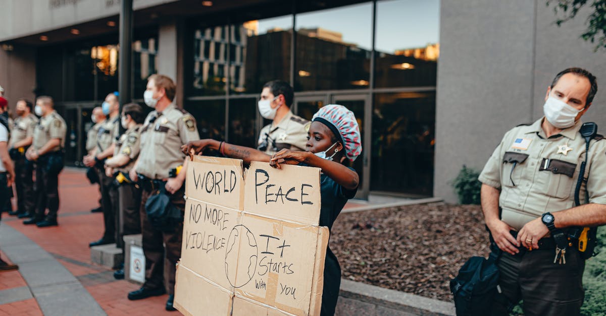 Re-entering Canada after minor contact with the police there - Person Protesting next to Cops Re-entering Canada after minor contact with the police there - Person Protesting next to Cops