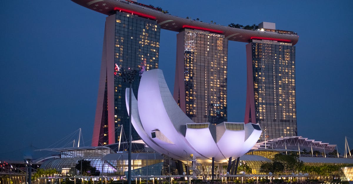 Re-entering Singapore on a multiple-entry visa - White and Red Building Near Body of Water during Night Time Re-entering Singapore on a multiple-entry visa - White and Red Building Near Body of Water during Night Time