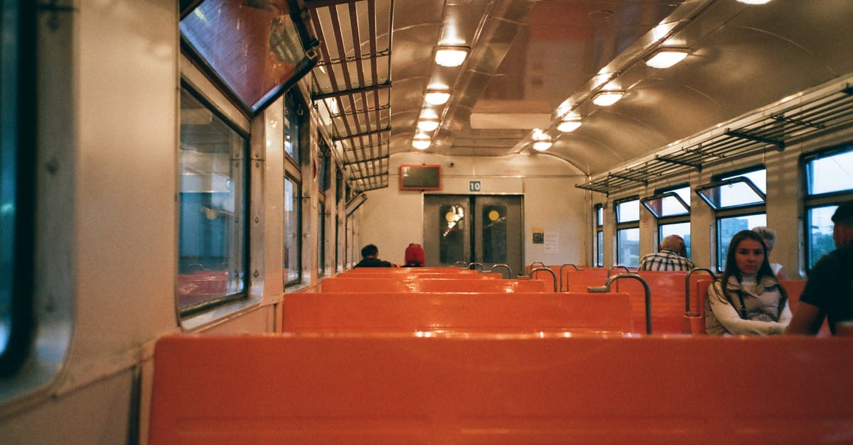 Regular train service from Antananarivo to Antsirabe? - Interior of train wagon with metal shelves ad bright seats with passengers riding Regular train service from Antananarivo to Antsirabe? - Interior of train wagon with metal shelves ad bright seats with passengers riding
