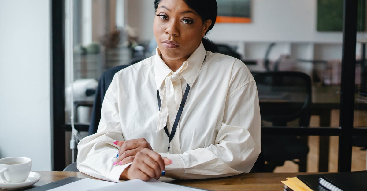 Reliable Mastercard ATMs in Antigua? - Serious black businesswoman sitting at desk in office Reliable Mastercard ATMs in Antigua? - Serious black businesswoman sitting at desk in office