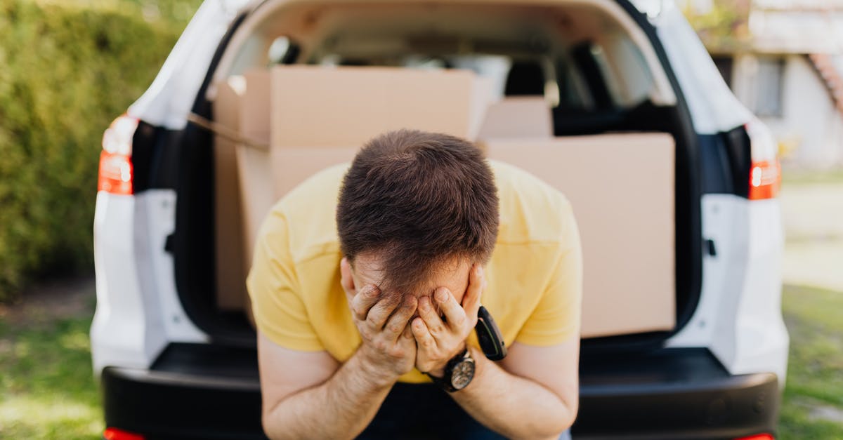 Rent car in Kuala Lumpur, drop off in Singapore? - Faceless frustrated tired male wearing casual outfit sitting on car luggage boot and covering face with hands during relocation on sunny summer day Rent car in Kuala Lumpur, drop off in Singapore? - Faceless frustrated tired male wearing casual outfit sitting on car luggage boot and covering face with hands during relocation on sunny summer day