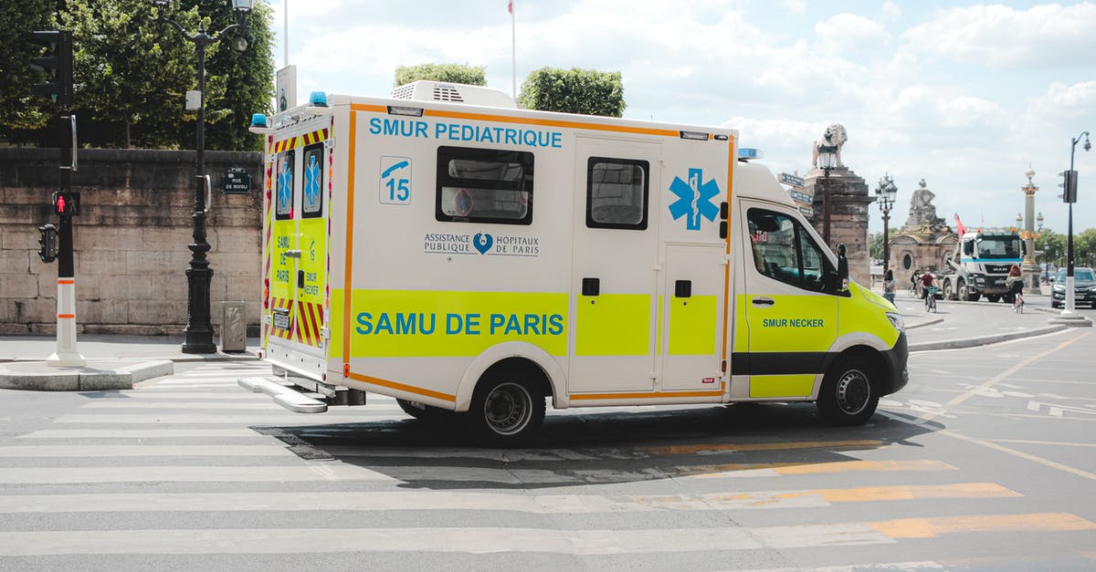 Rental Car Insurance in Jamaica - Ambulance driving along road in sunny city Rental Car Insurance in Jamaica - Ambulance driving along road in sunny city