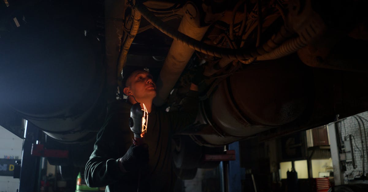 Renting a car in Israel when under 21? - A Man Holding a light Checking Under a Vehicle Renting a car in Israel when under 21? - A Man Holding a light Checking Under a Vehicle