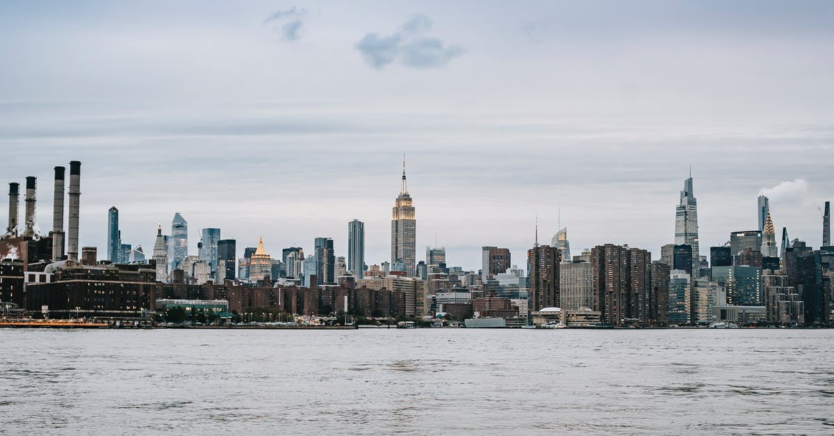 Renting a car on the east coast USA - Cityscape of contemporary New York City district with famous skyscrapers situated on East River shore under clear sky Renting a car on the east coast USA - Cityscape of contemporary New York City district with famous skyscrapers situated on East River shore under clear sky