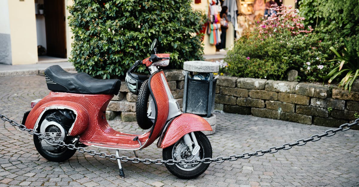 Renting a mobility scooter in Bergamo, Italy - Red and Black Motor Scooter Parked Beside Green Plants Renting a mobility scooter in Bergamo, Italy - Red and Black Motor Scooter Parked Beside Green Plants