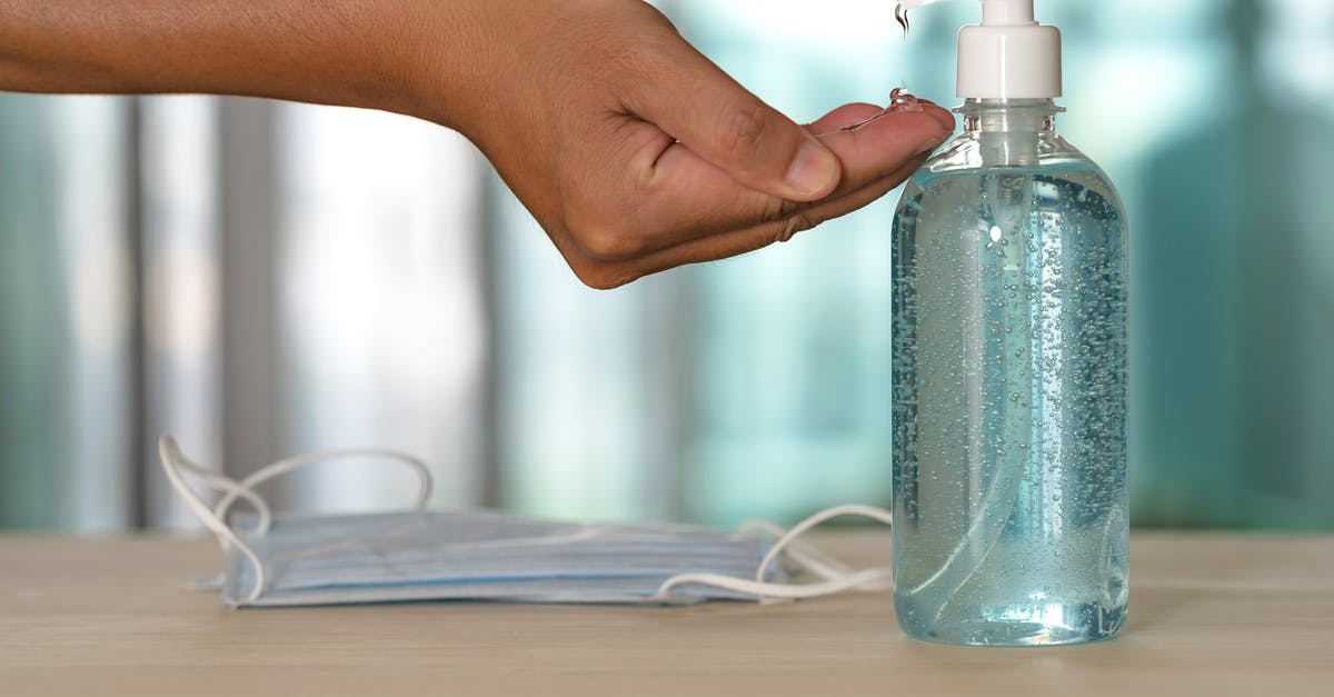 Requirement to pay for quarantine when entering New Zealand? - Faceless person using antibacterial gel from dispenser during quarantine period
