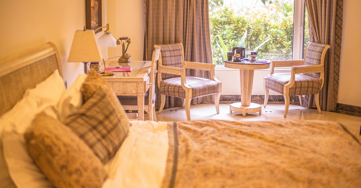 Residence permit no. or equivalent on a visa free stay - Comfortable sunny hotel room with soft bed and classic armchairs placed near big window aside white vanity table
