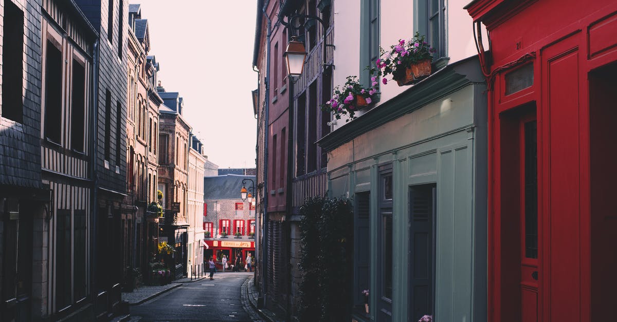 Resource to find regular flights between given cities - Paved road on narrow alley between residential building with colorful facade and windows located in town on street against cloudless sky Resource to find regular flights between given cities - Paved road on narrow alley between residential building with colorful facade and windows located in town on street against cloudless sky