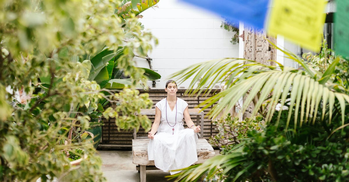 Retreat center for meditation near Frankfurt - Woman in White Dress Sitting on White Wooden Bench Surrounded by Green Plants Retreat center for meditation near Frankfurt - Woman in White Dress Sitting on White Wooden Bench Surrounded by Green Plants