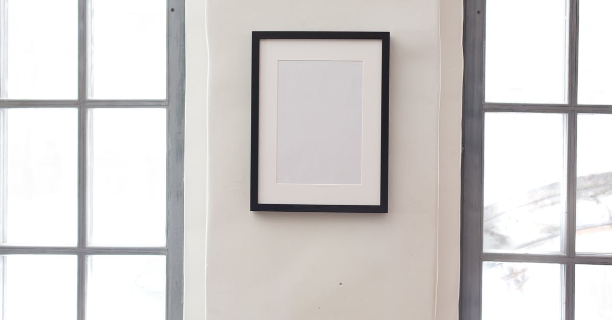 Retrieving Bags To Clear Customs/Lounge Access Upon Arrival - Interior of simple apartment with blank frame on white wall between rectangular shaped windows Retrieving Bags To Clear Customs/Lounge Access Upon Arrival - Interior of simple apartment with blank frame on white wall between rectangular shaped windows