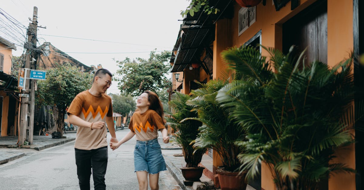 Return date earlier than Departure date on the same flight booking - Cheerful Asian couple running on street