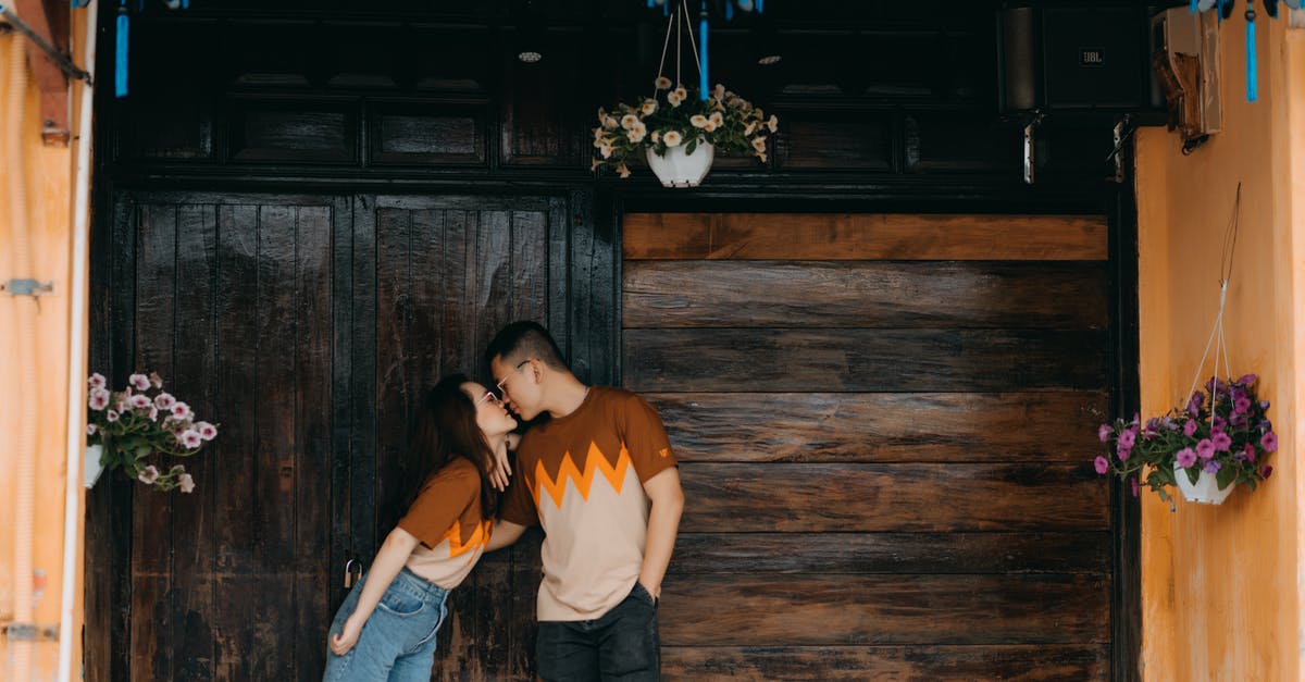 Return date earlier than Departure date on the same flight booking - Romantic Asian couple kissing near wooden wall