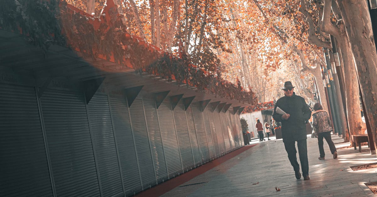 Return trip mandatory when leaving Australia? [closed] - Man in black clothes walking along closed outside shops