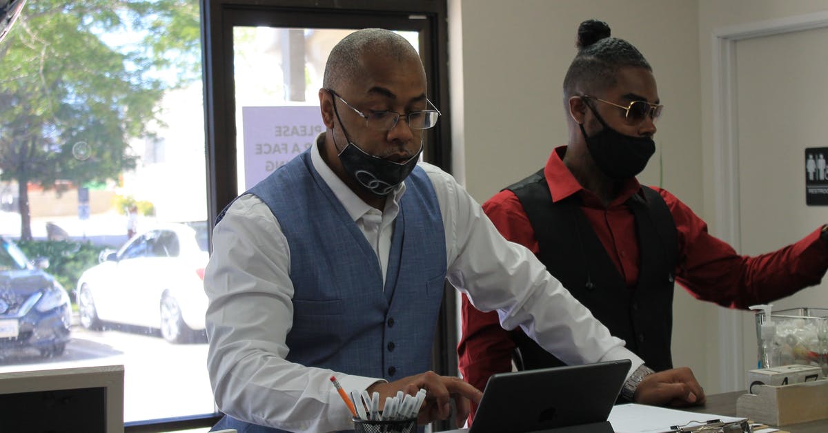 Returning expired I-94 - Man Using an iPad Beside His Friend Returning expired I-94 - Man Using an iPad Beside His Friend