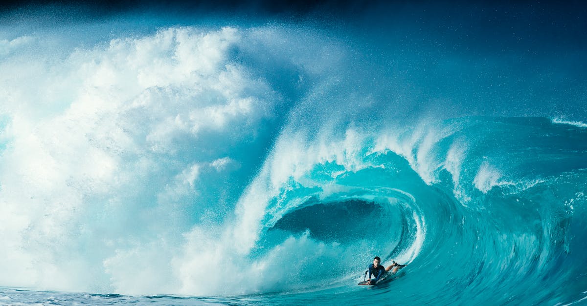 Ride hailing options in Crimea as of summer 2020 - Scenery of male surfer lying on surfboard and riding turquoise foamy sea waves on sunny day Ride hailing options in Crimea as of summer 2020 - Scenery of male surfer lying on surfboard and riding turquoise foamy sea waves on sunny day