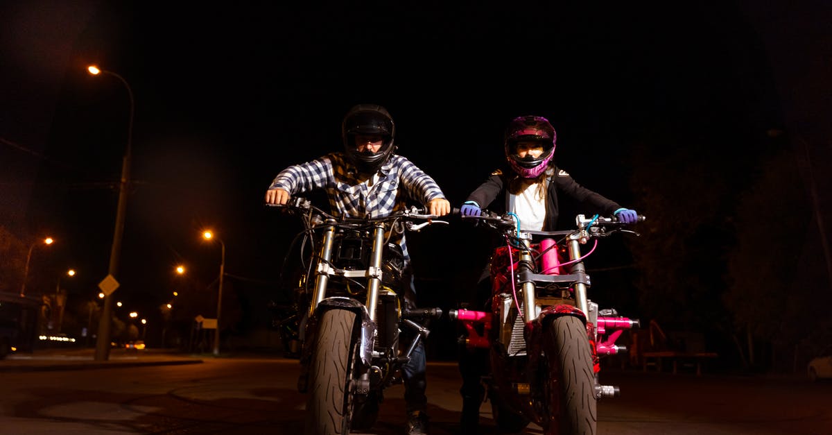 Riding an Abra at Night (Dubai) - A Man and a Woman Riding Their Motorcycles at Night Riding an Abra at Night (Dubai) - A Man and a Woman Riding Their Motorcycles at Night