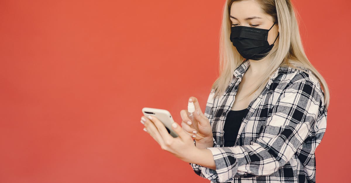 Risk of not turning Airplane Mode on, on a mobile device while in the air? - Young woman disinfecting smartphone during coronavirus pandemic Risk of not turning Airplane Mode on, on a mobile device while in the air? - Young woman disinfecting smartphone during coronavirus pandemic