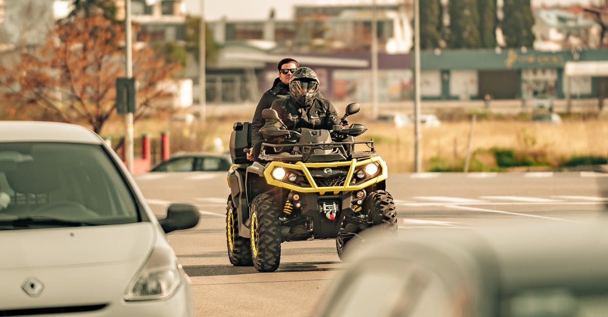 Road trip distance/driving time planning - Unrecognizable friends riding quad bike on city road in sunlight Road trip distance/driving time planning - Unrecognizable friends riding quad bike on city road in sunlight