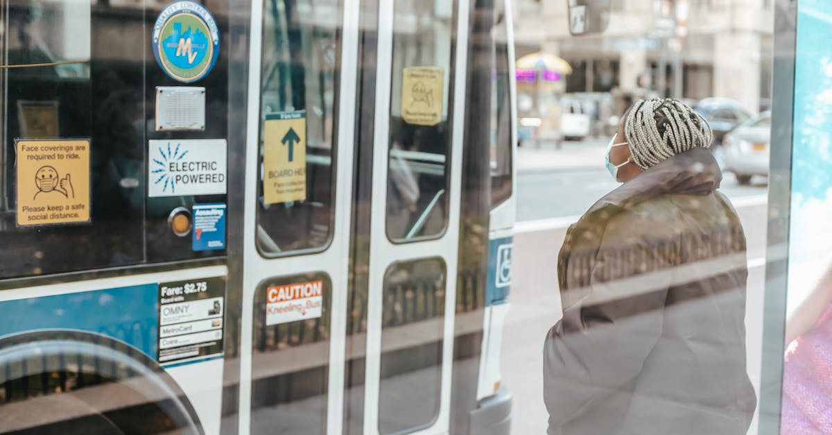 Road Trip Through Sedona, AZ [closed] - Through glass wall back view of anonymous ethnic female medic standing against public transport in town