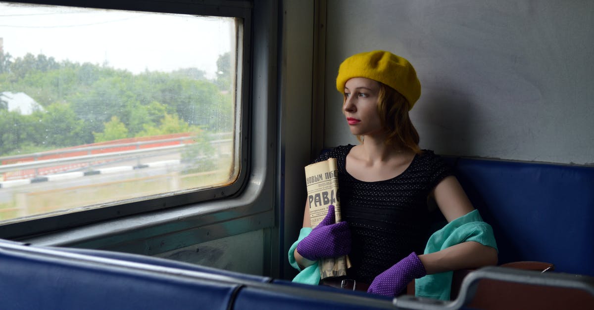 Russia visa registration when staying on the move - Pensive woman with newspaper in train Russia visa registration when staying on the move - Pensive woman with newspaper in train