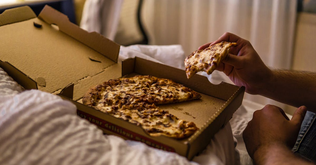 Russian National with permanent Italian Residence card going to Curacao - Faceless man enjoying delicious pizza lying in bed at home Russian National with permanent Italian Residence card going to Curacao - Faceless man enjoying delicious pizza lying in bed at home