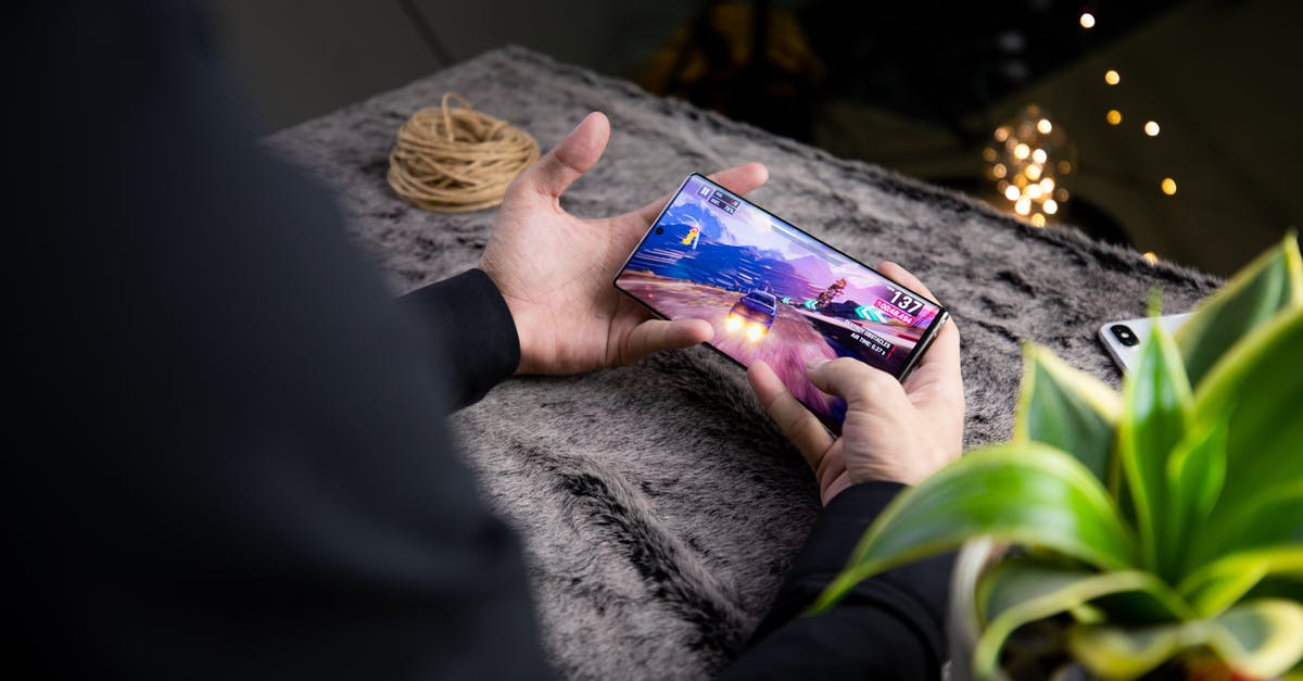 Russian visa goes in effect at what time? - From above of crop anonymous person playing video game on modern cellphone with image of car on screen Russian visa goes in effect at what time? - From above of crop anonymous person playing video game on modern cellphone with image of car on screen