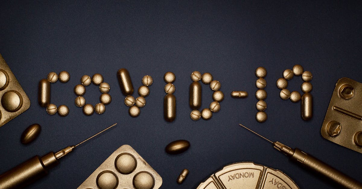 Rwanda: Yellow fever vaccination required? - Syringe and Pills on Blue Background Rwanda: Yellow fever vaccination required? - Syringe and Pills on Blue Background
