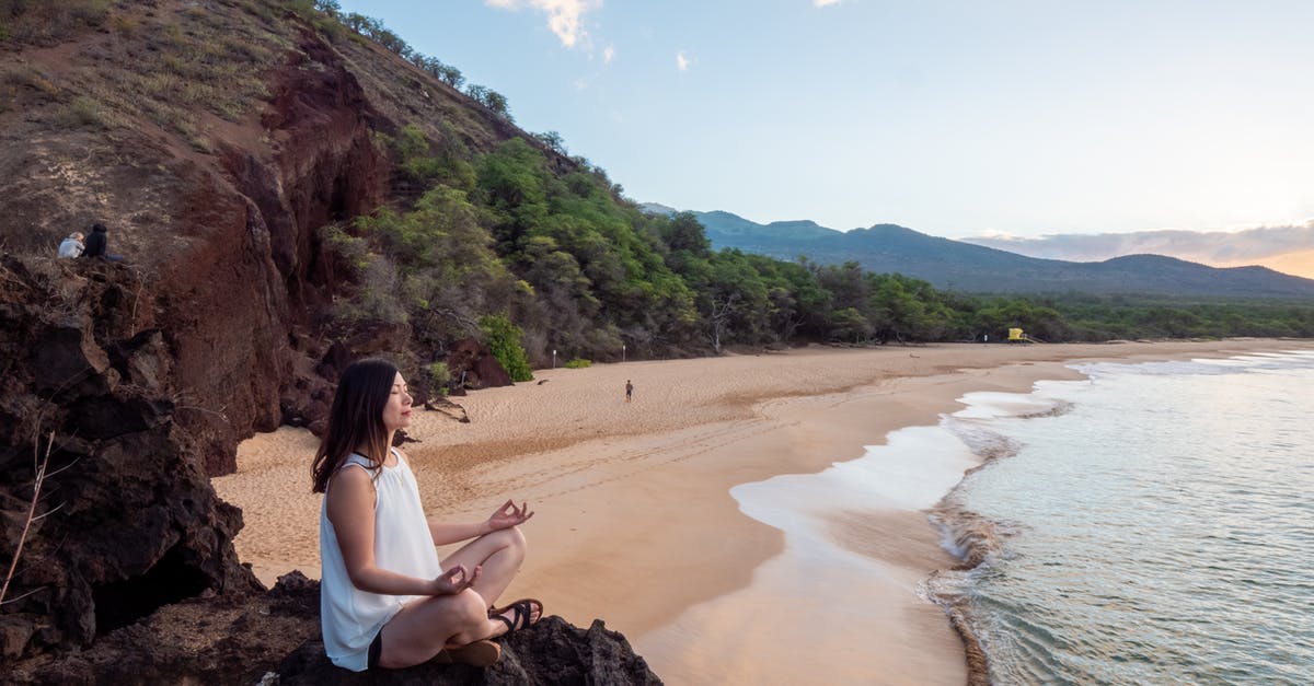 Safeguarding against extra expenditures Natural disasters during travels - Young ethnic woman meditate on empty beach Safeguarding against extra expenditures Natural disasters during travels - Young ethnic woman meditate on empty beach