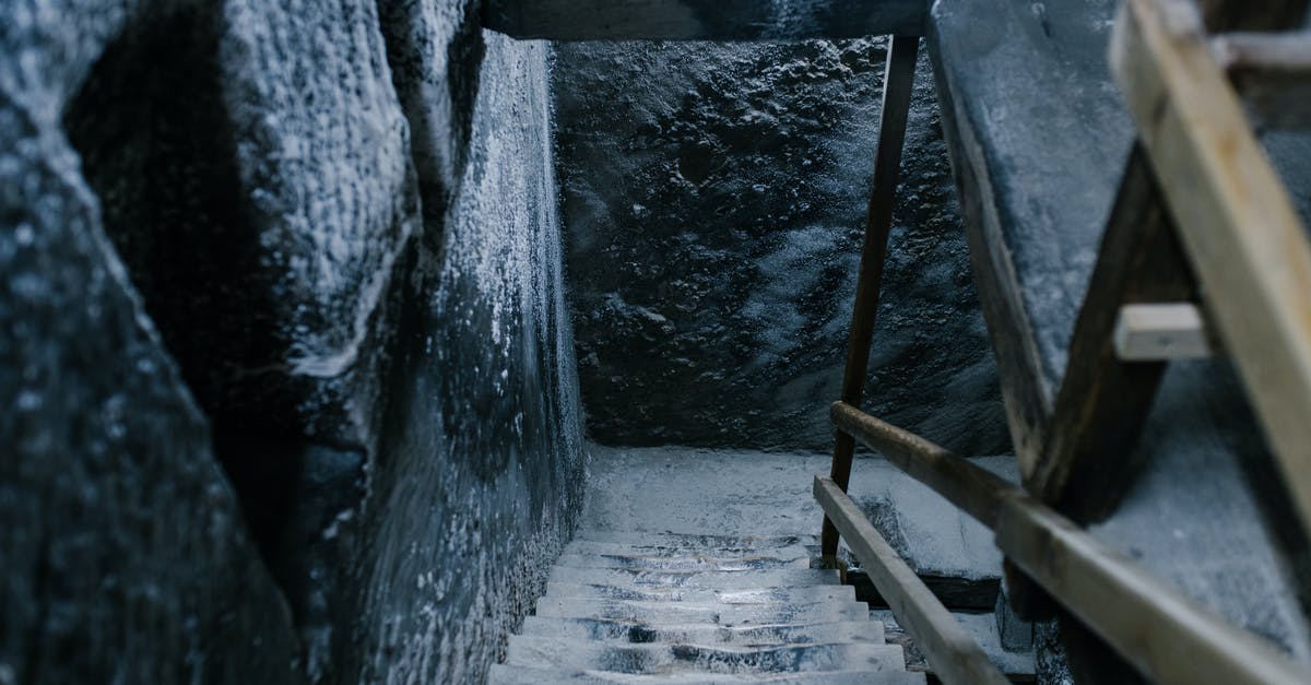 Salt mines in Poland -- differences between Wieliczka and Bochnia? - From above of aged stone stairway covered with salt in ancient cave with shabby walls and wooden railings in Registry Chamber of Salina Turda mine Salt mines in Poland -- differences between Wieliczka and Bochnia? - From above of aged stone stairway covered with salt in ancient cave with shabby walls and wooden railings in Registry Chamber of Salina Turda mine