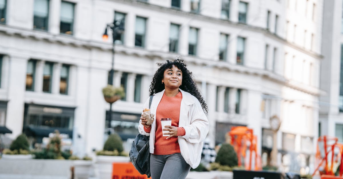 Sandwich alternatives for city trips - Happy black woman with takeaway coffee and sandwich on street Sandwich alternatives for city trips - Happy black woman with takeaway coffee and sandwich on street