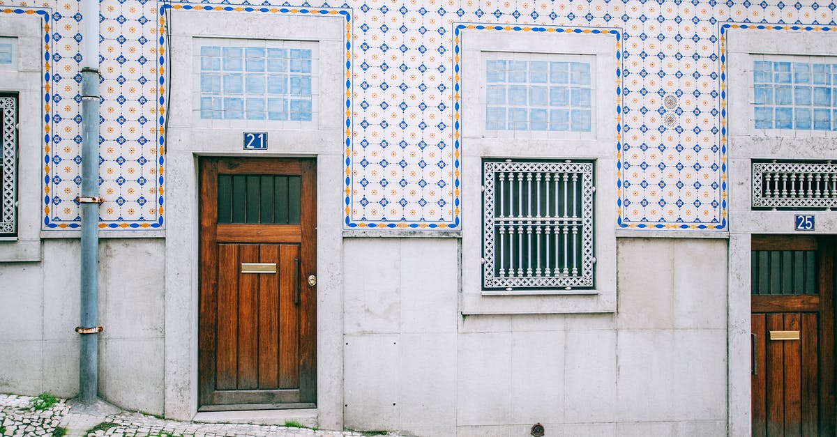 Schengen area entry point rules when no visa is needed [duplicate] - Facade of modern residential building with wooden doors and ornamental tiled walls in daylight