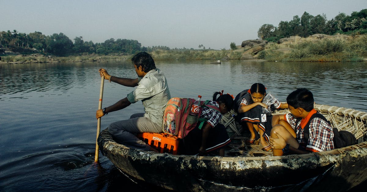Schengen travel with minor Indian child born in Netherlands - Group of Indian man and schoolchildren with backpacks sitting in handmade boat while floating on water to school Schengen travel with minor Indian child born in Netherlands - Group of Indian man and schoolchildren with backpacks sitting in handmade boat while floating on water to school
